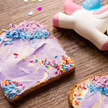 Unicorn Toast Laying on a table with sprinkles and a toy unicorn