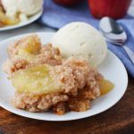 Crockpot Apple Dump Cake served warm on a plate with vanilla ice cream