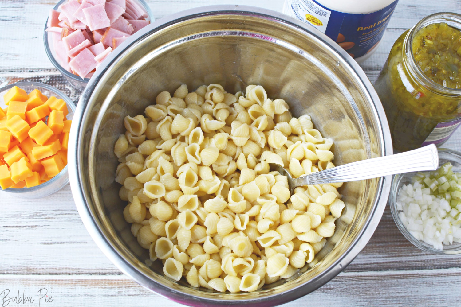 Macaroni salade met ham en kaas ingrediënten zijn o.a. selderij, cheddarkaas en mayonaise