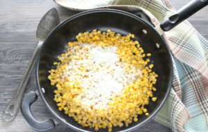 adding ranch mix to corn.