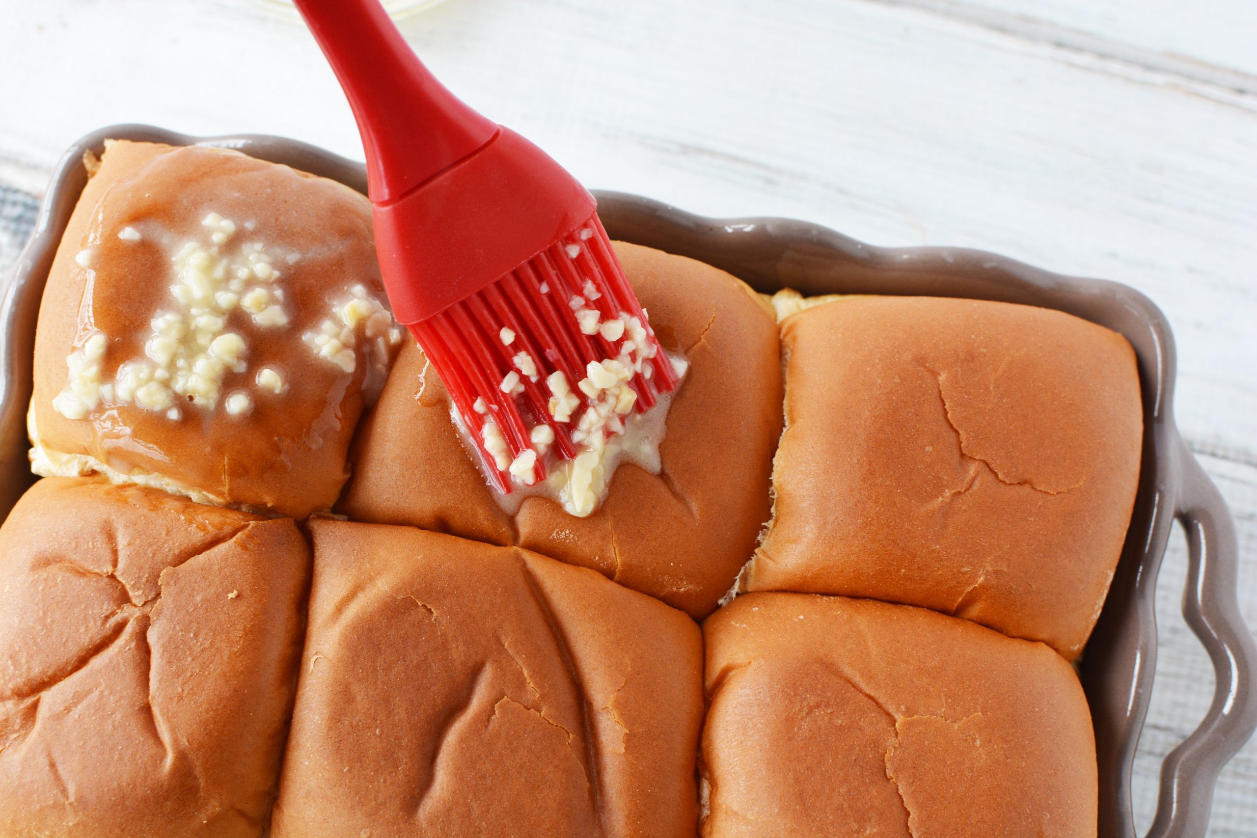 Chicken Parmesan Sliders are topped with a mix of garlic and butter.