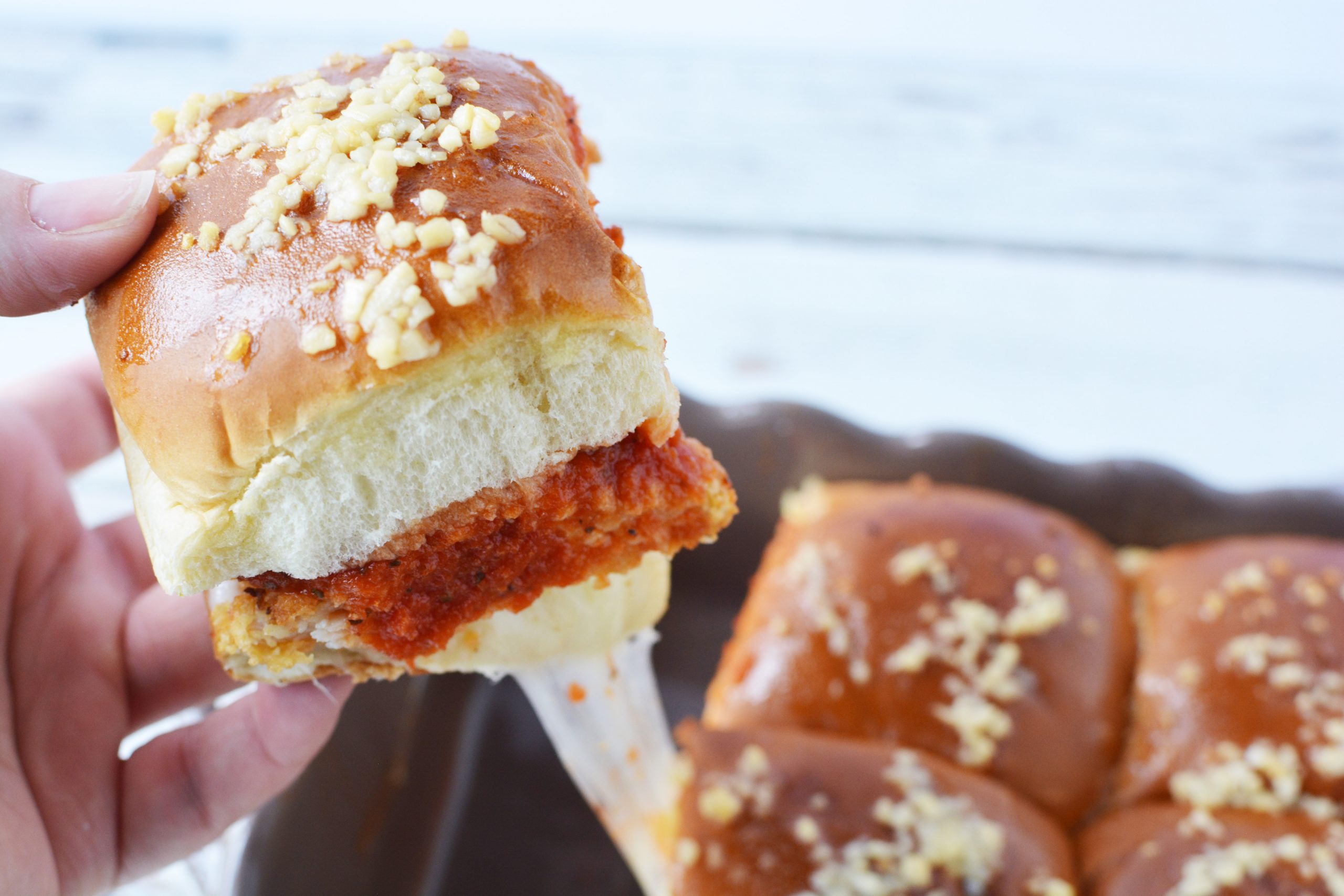 Chicken Parmesan Sliders Recipe has breaded chicken, marinara sauce and provolone cheese on a hawaiian roll.