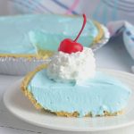 Kool Aid Pie topped with whipped cream and a cherry.