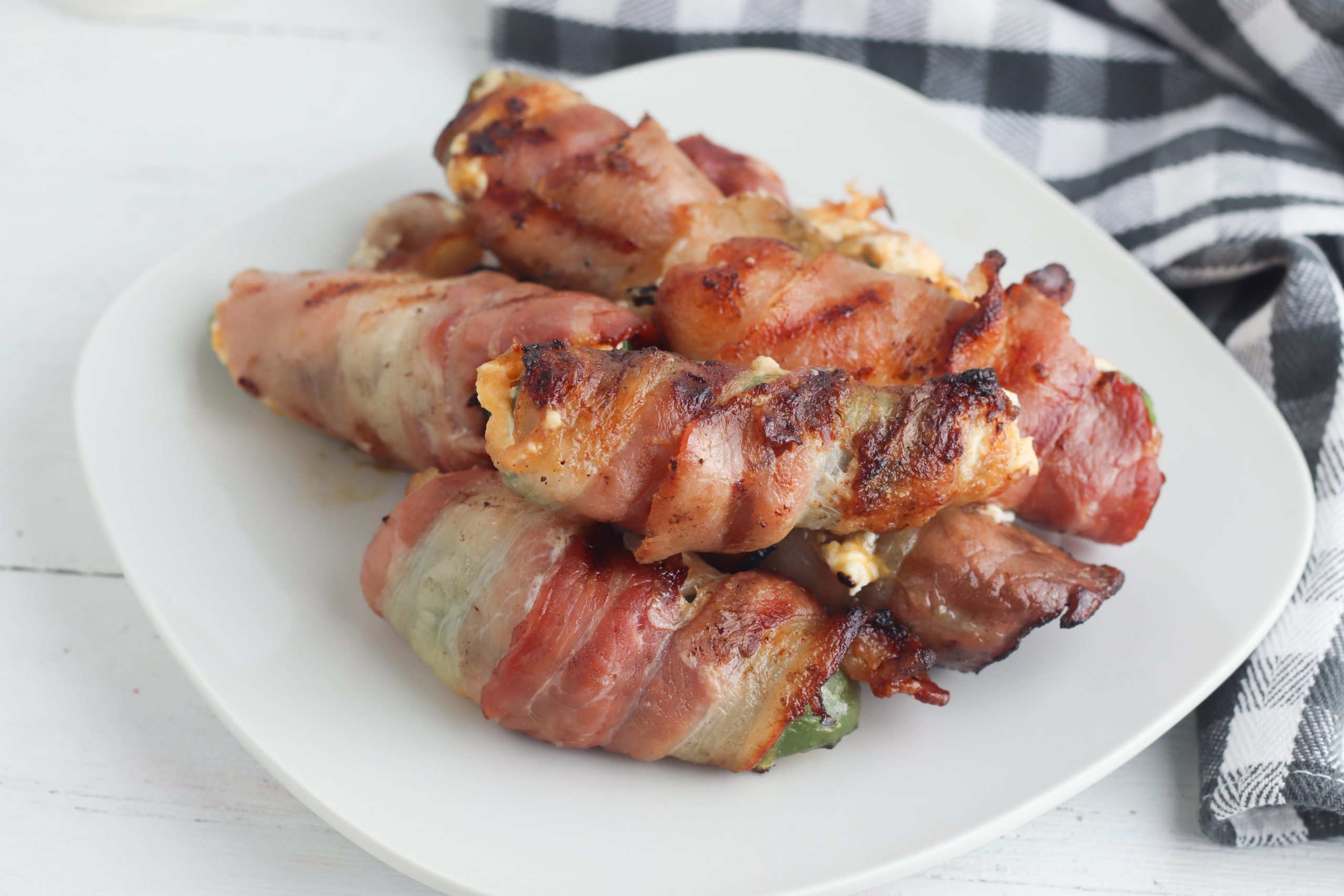 Grilled Jalapeno Poppers are wrapped in bacon and grilled to crispy perfection. Cheesy and spicy, they make an awesome appetizer. 