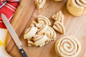 Cut cinnamon rolls into quarters and place into baking dish.