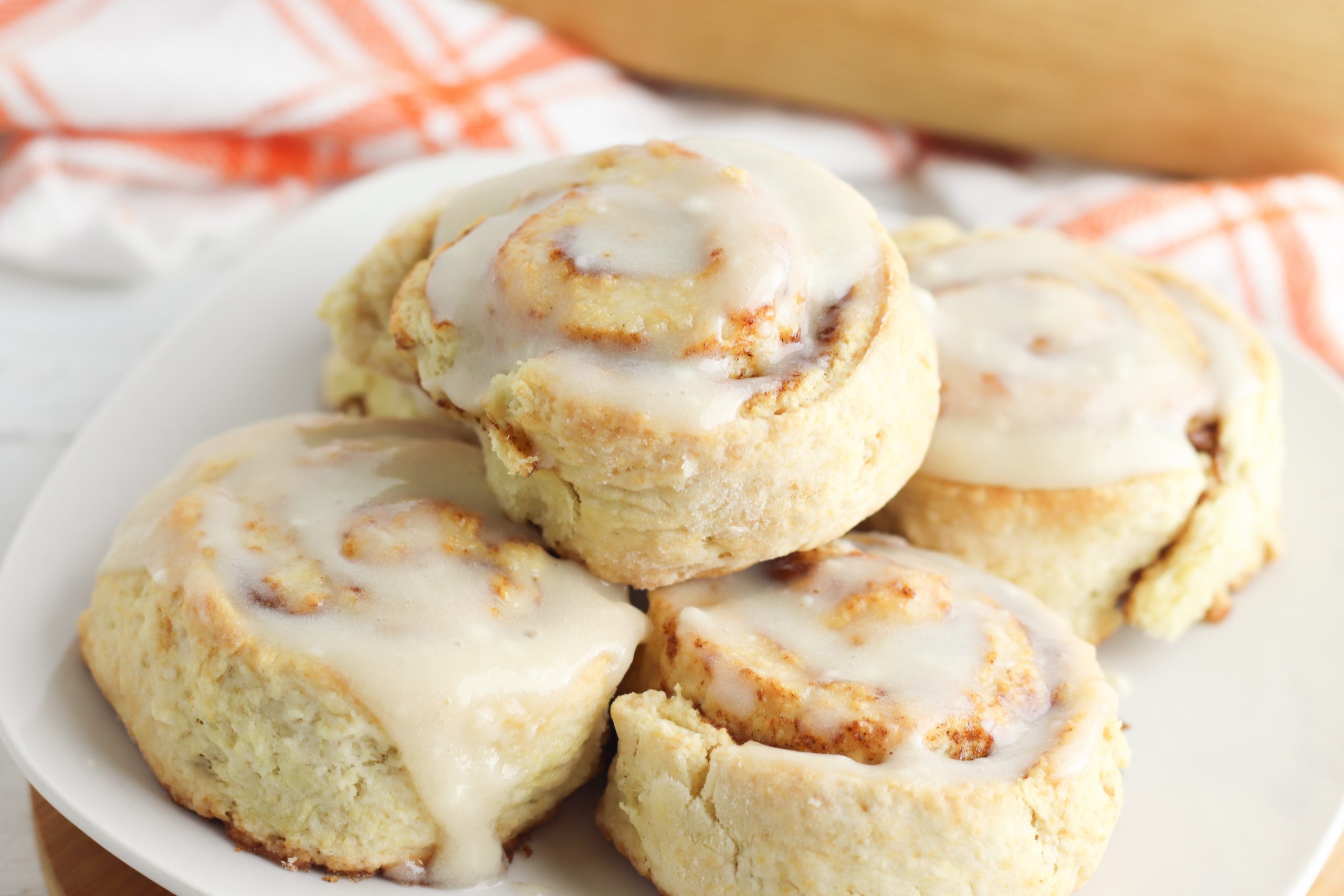 Pumpkin Cinnamon Rolls with a cream cheese glaze on a serving plate.