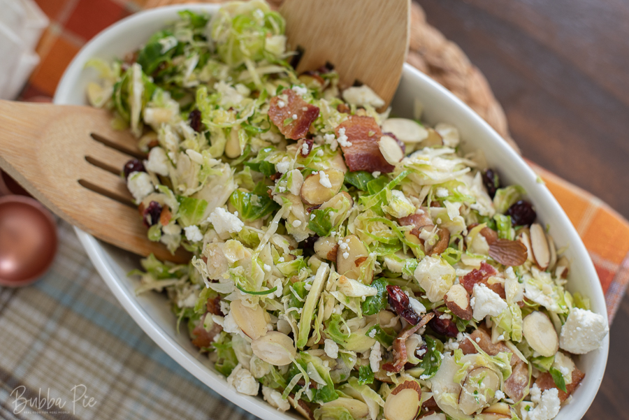 Brussels Sprouts, Bacon, Cranberries and Feta being dished on a table.
