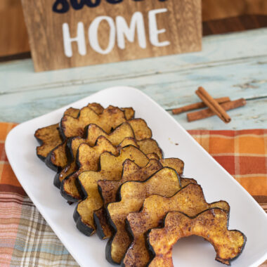 Roasted Acorn Squash being served for dinner with Fall decorations.