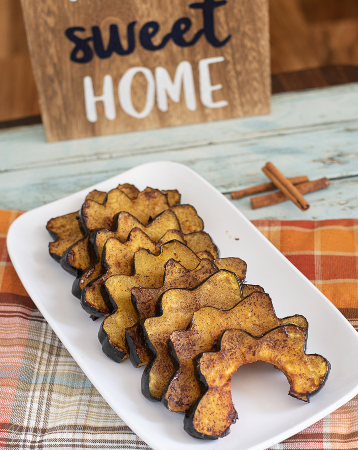 Roasted Acorn Squash being served for dinner with Fall decorations. 