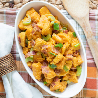 Sweet Potato Salad being served on a table with Thanksgiving decorations.