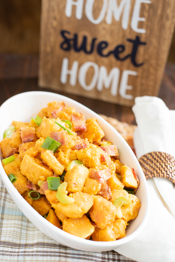 Sweet Potato Salad Recipe with bacon, celery and green onions being served as a side dish.