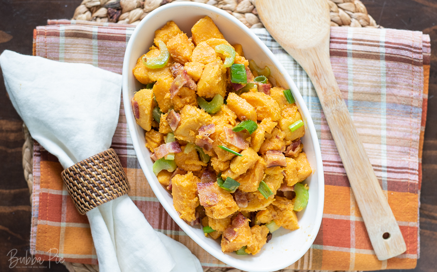 Sweet Potato Salad being served on a table with Thanksgiving decorations.