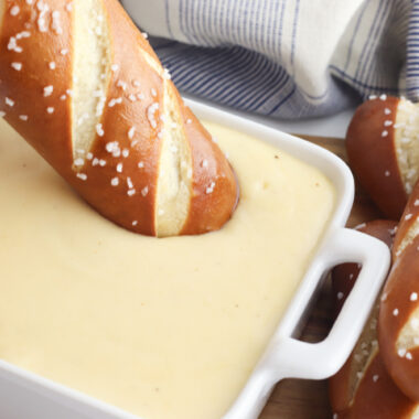 Dipping a soft pretzel in Beer Cheese Dip.