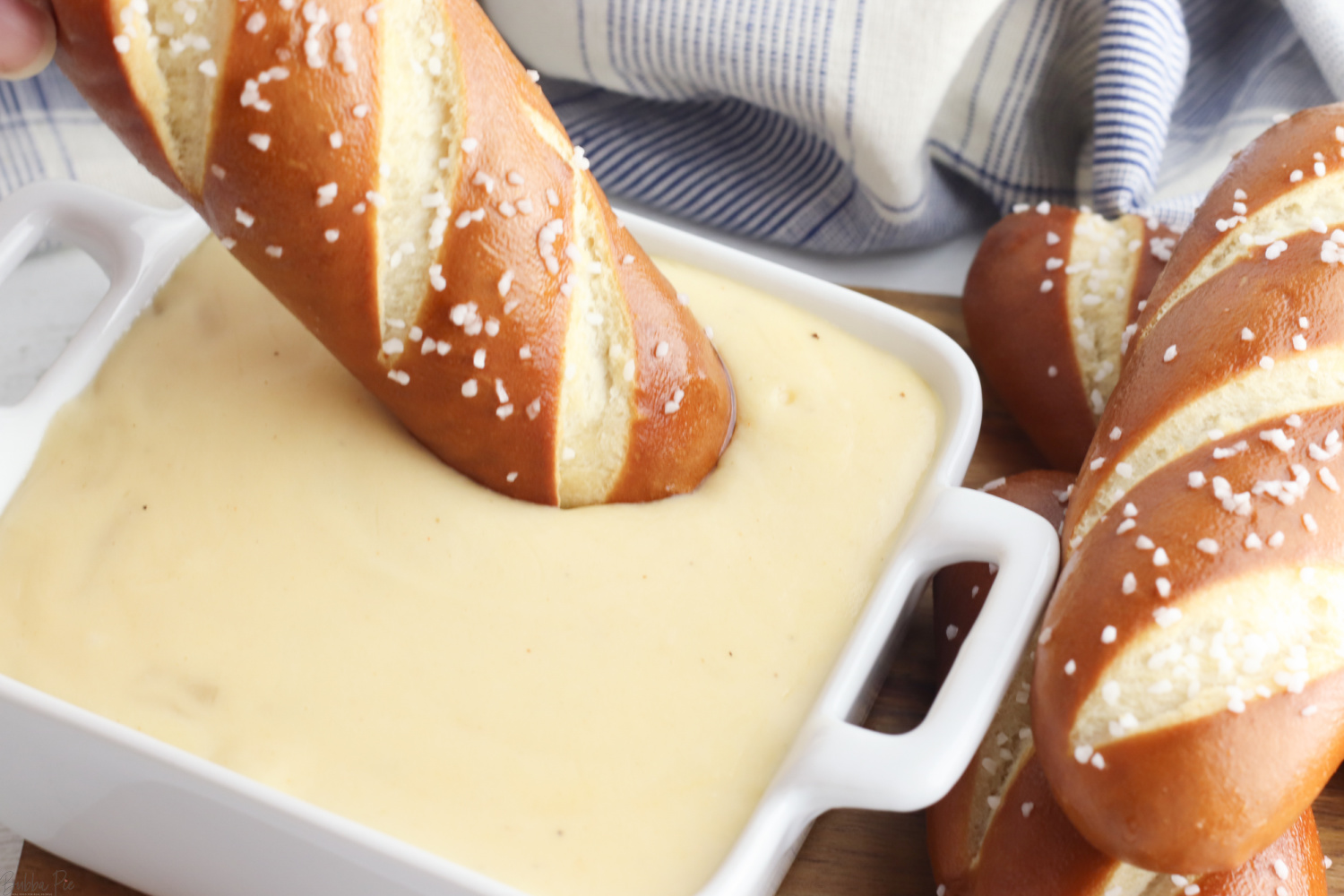 Dipping a soft pretzel in Beer Cheese Dip.