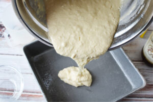 pouring coffee cake batter into prepared pan
