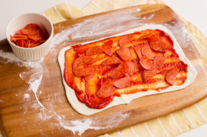 Add pepperoni to pastry