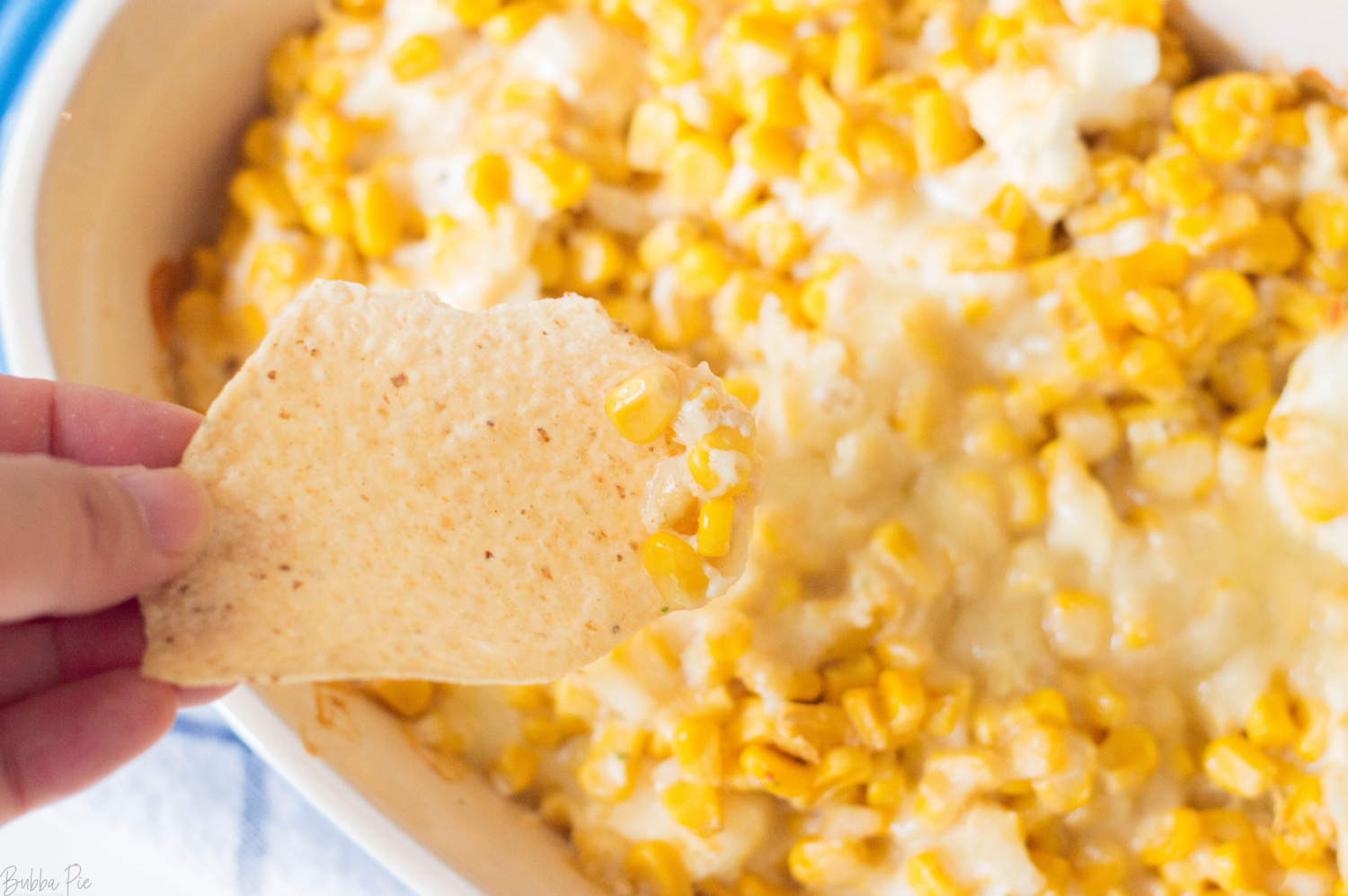 Cheesy Hot Corn Dip on a tortilla chip.