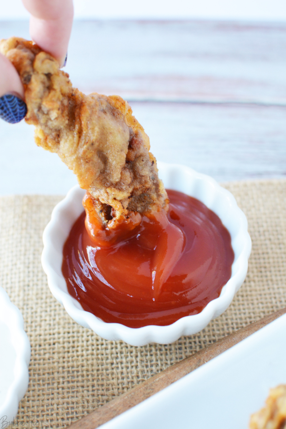 Steak Fries being dipped into ketchup.