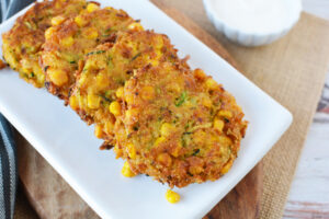 Zucchini Corn Fritters being served on a white plate.