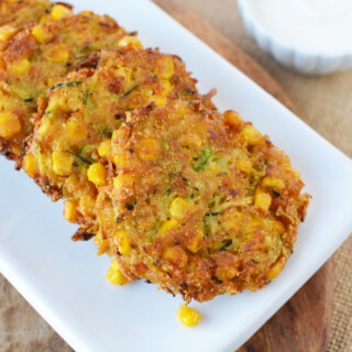 Zucchini Corn Fritters being served on a white plate.