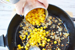 Cooking Butter, garlic, onions and corn for fritters.