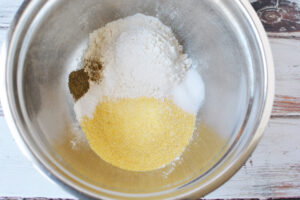 Add flour, cornmeal, salt, pepper and baking soda to a bowl and mix well.