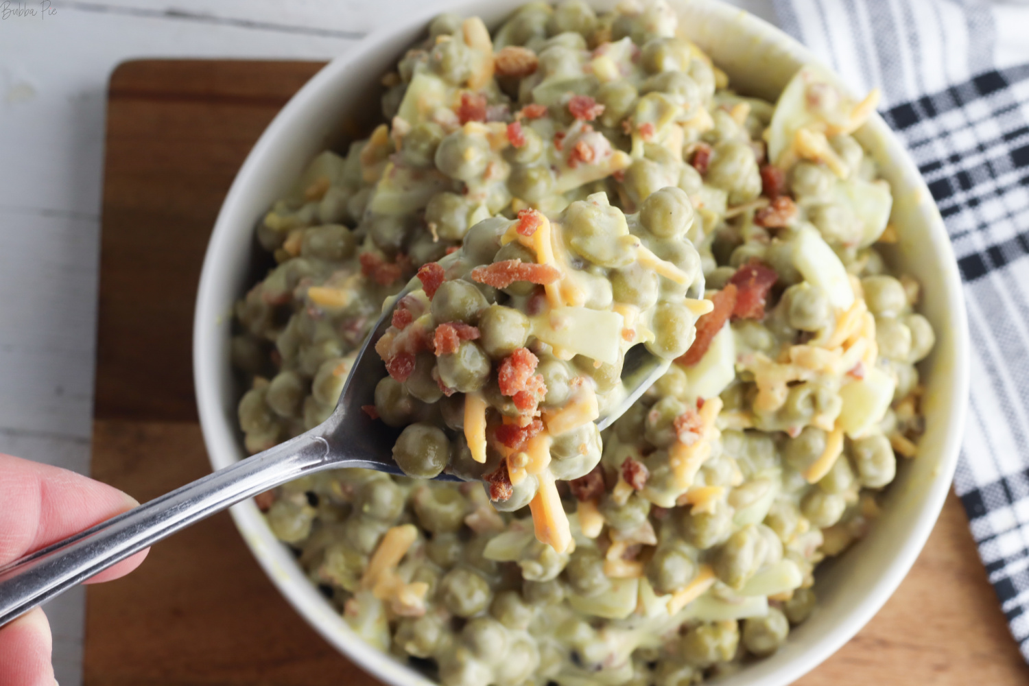 Pea Salad Recipe on a spoon being dished for dinner.