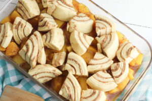 place cinnamon rolls on top of peaches