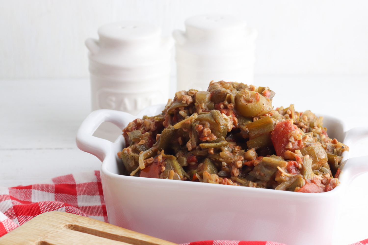 vegetarian smothered okra being served in a white dish.