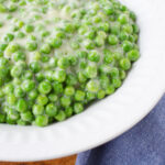 Creamed Peas in a white bowl.