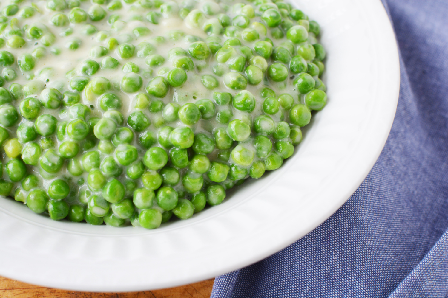 Creamed Peas in a white bowl.