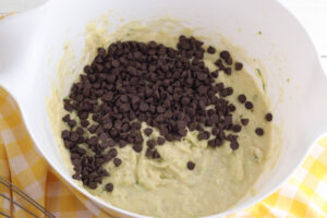 adding chocolate chips to muffins