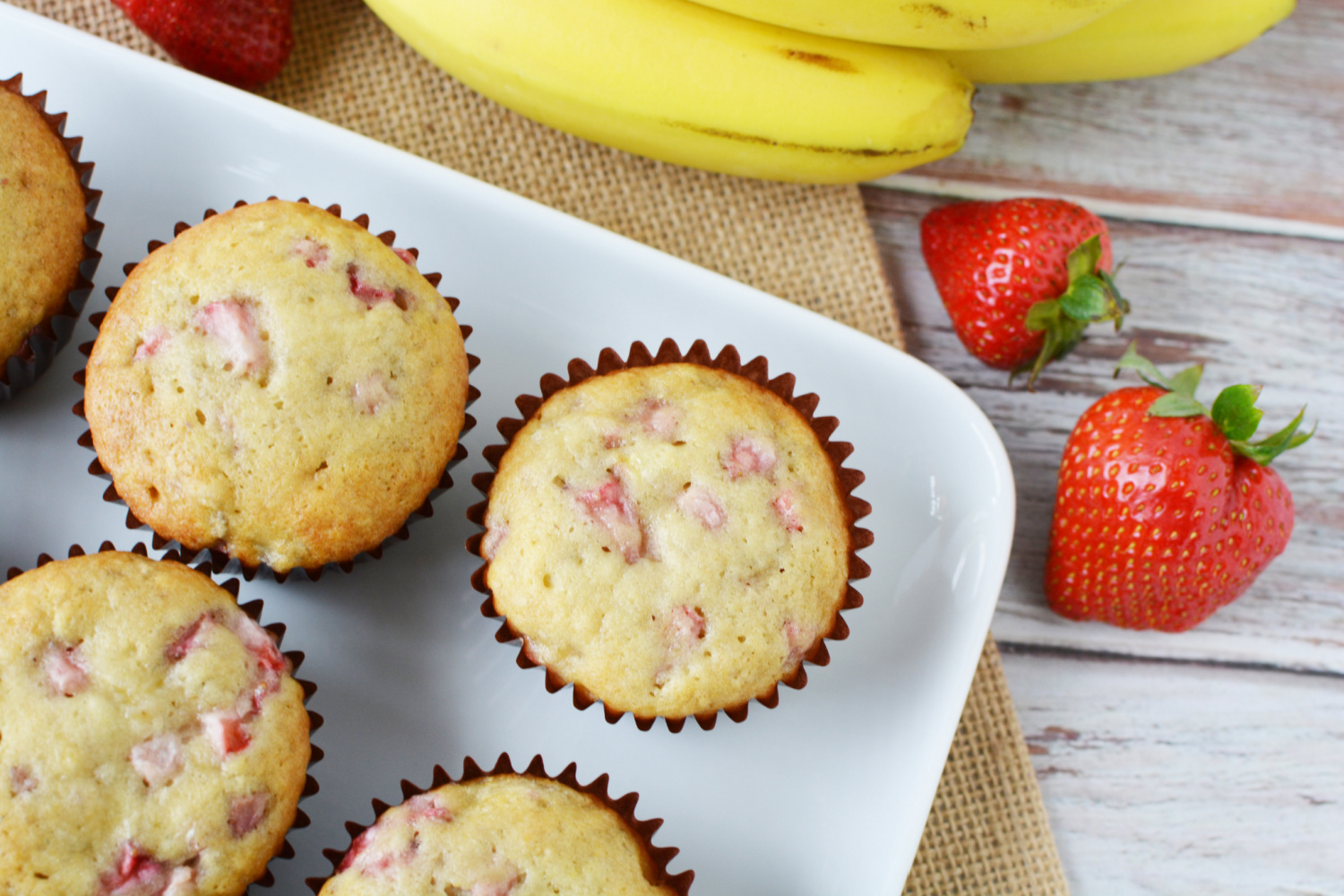 Strawberry Banana Muffins in a muffin tin coming out of oven.