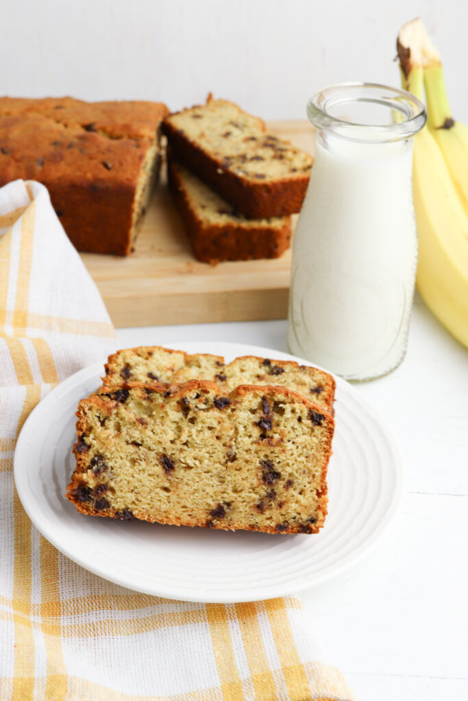 banana bread on a white plate with milk.