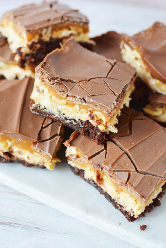 Snickers Brownie Bars on a white plate.