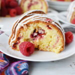 White Chocolate Raspberry Bundt Cake being served on a white plate.