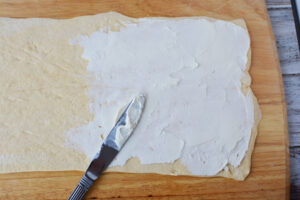 spread cream cheese on crescent roll dough