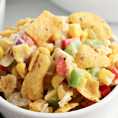 frito corn salad being served in a white bowl