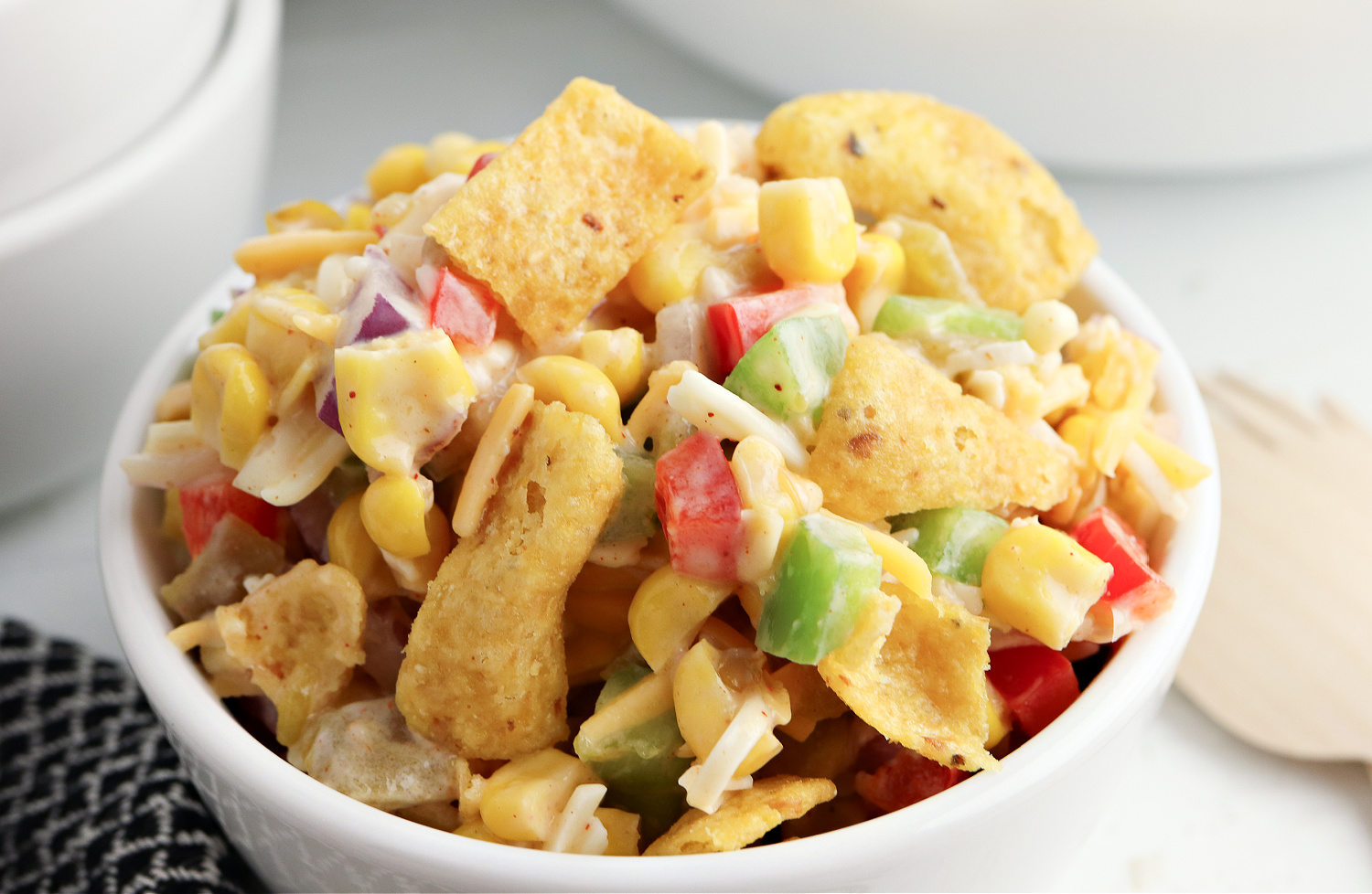 frito corn salad being served in a white bowl